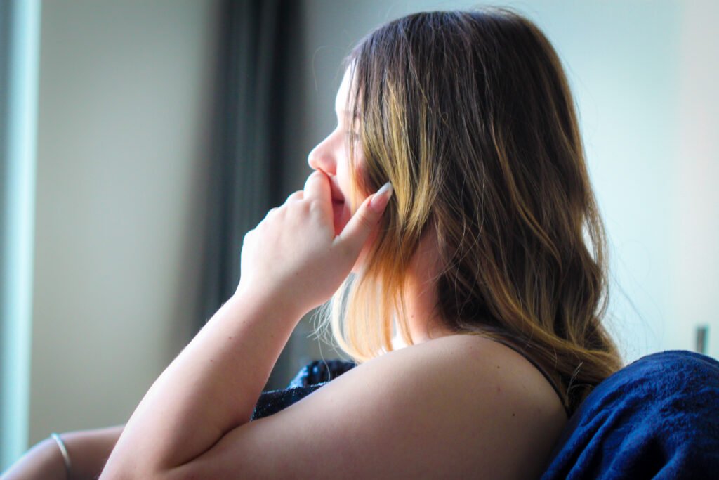 Senior Photography, picture of a beautiful young woman looking into the sunlight bouncing off a mirror